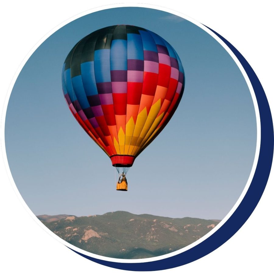 a hot air balloon floating over mountains